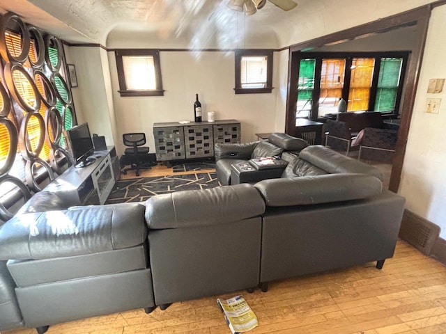 living area featuring hardwood / wood-style flooring and a ceiling fan