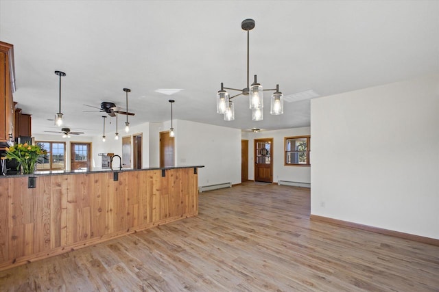 kitchen with a peninsula, a wealth of natural light, and a baseboard radiator