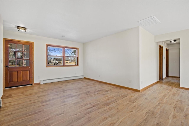 unfurnished room with baseboard heating, visible vents, baseboards, and light wood-style floors