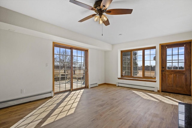 foyer featuring a baseboard heating unit and wood finished floors