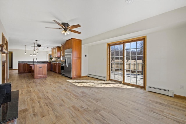 kitchen with dark countertops, a breakfast bar area, stainless steel fridge with ice dispenser, and baseboard heating