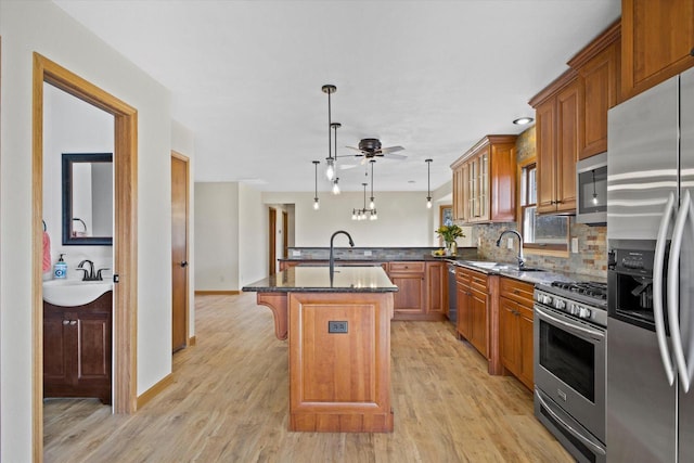 kitchen with brown cabinets, appliances with stainless steel finishes, and a sink