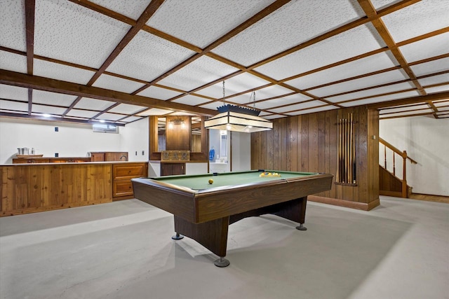 game room featuring indoor wet bar, wooden walls, pool table, and concrete floors