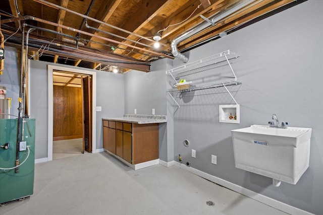 clothes washing area with laundry area, a heating unit, baseboards, and washer hookup