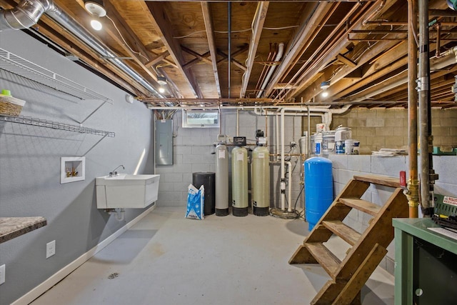 basement featuring electric panel and a sink