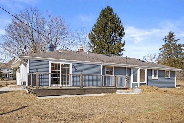 rear view of house featuring a chimney, a shingled roof, and a deck