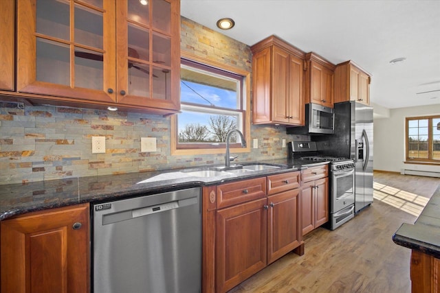 kitchen with a sink, brown cabinetry, light wood finished floors, and stainless steel appliances