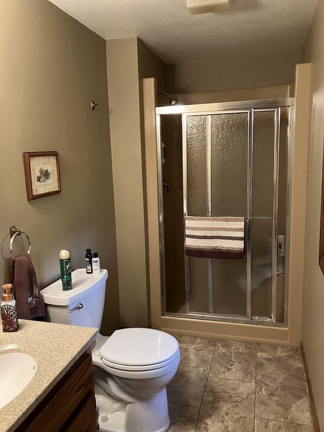 full bathroom featuring vanity, a shower stall, and toilet