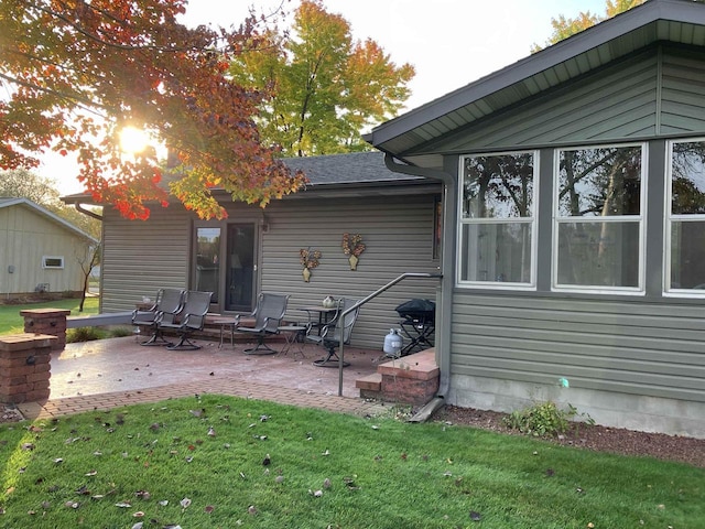 rear view of property with a lawn and a patio