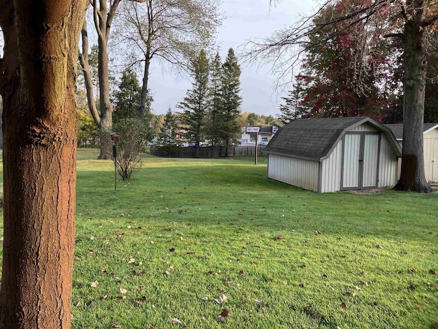 view of yard with an outbuilding, fence, and a shed