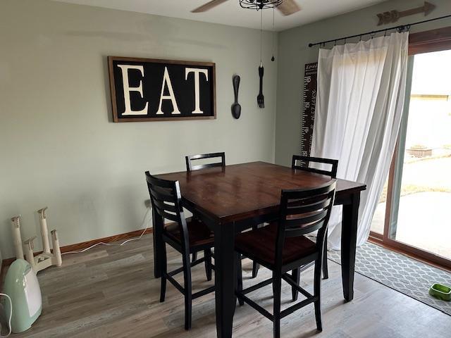 dining room featuring light wood-style floors, baseboards, and ceiling fan