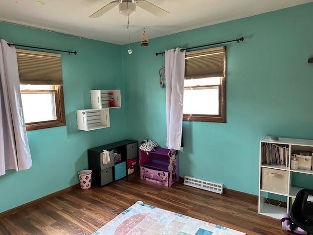 bedroom featuring visible vents, a ceiling fan, baseboards, and wood finished floors