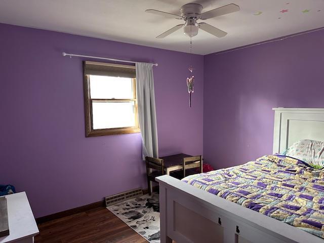 bedroom featuring visible vents, dark wood-style flooring, and ceiling fan