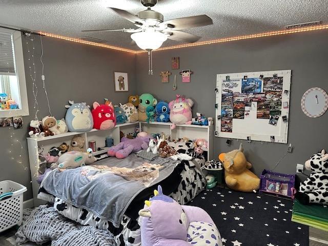 bedroom featuring a ceiling fan and a textured ceiling