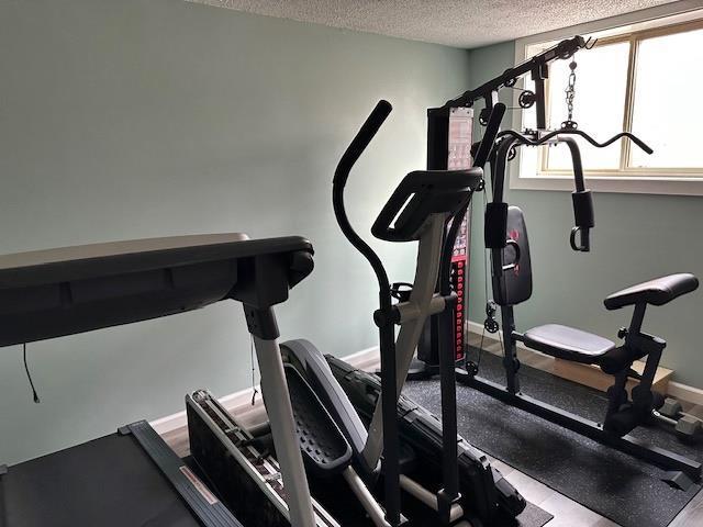 exercise area featuring baseboards and a textured ceiling