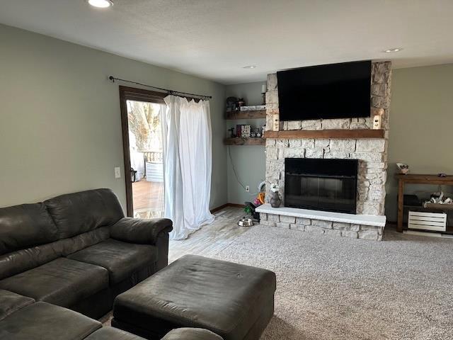 living room featuring a stone fireplace