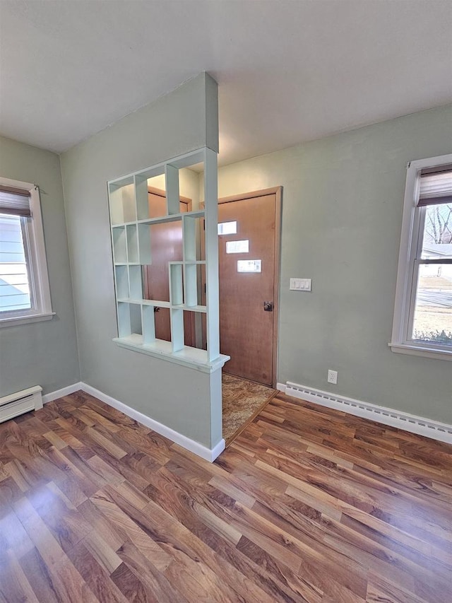 entrance foyer with a baseboard heating unit, wood finished floors, baseboards, and baseboard heating