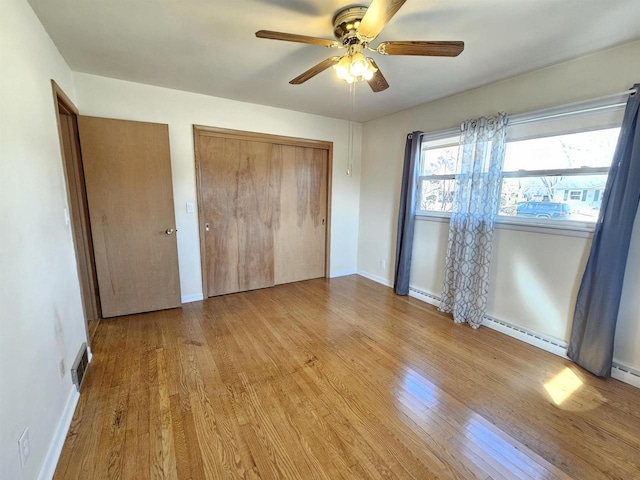 unfurnished bedroom featuring visible vents, a ceiling fan, wood finished floors, a closet, and baseboards