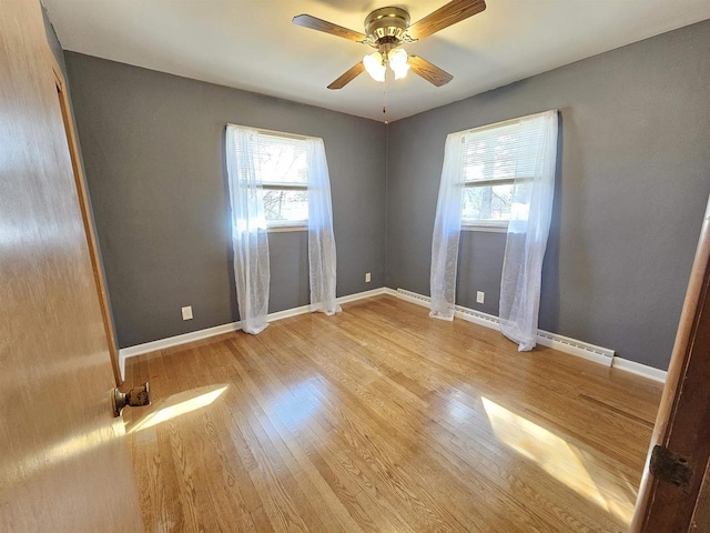 unfurnished room with light wood finished floors, ceiling fan, and baseboards