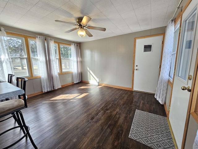 interior space with visible vents, baseboards, wood finished floors, and a ceiling fan