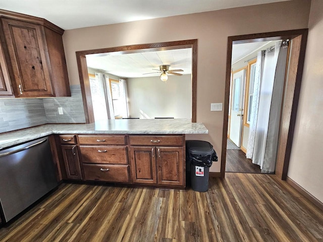 kitchen featuring backsplash, dark wood-type flooring, dishwasher, light countertops, and a peninsula