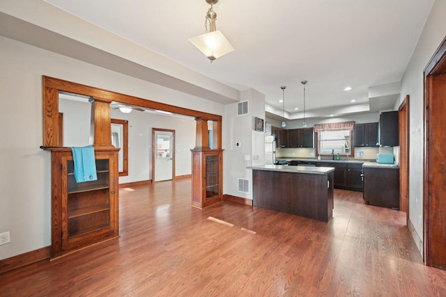 kitchen featuring visible vents, light countertops, baseboards, and wood finished floors