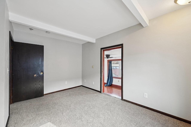 interior space with beam ceiling, baseboards, and carpet floors