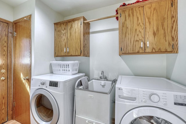 laundry room featuring a sink, cabinet space, and separate washer and dryer