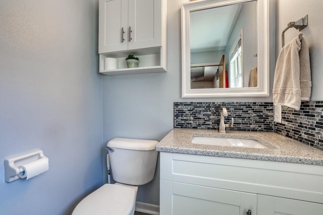 half bath with backsplash, toilet, and vanity