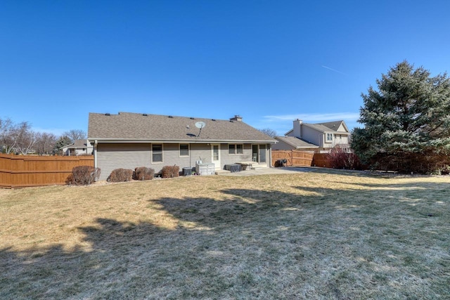 back of house featuring a lawn, a fenced backyard, and a patio area