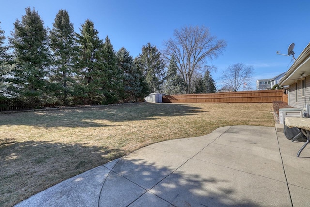 view of yard featuring a patio area, a shed, an outbuilding, and a fenced backyard