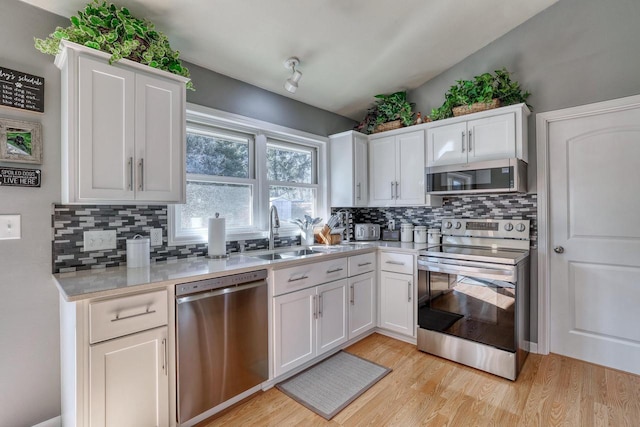 kitchen featuring light countertops, white cabinets, appliances with stainless steel finishes, and a sink