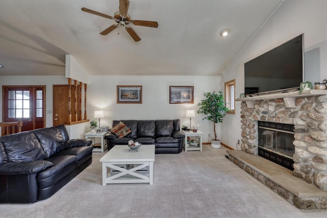 living room with ceiling fan, baseboards, lofted ceiling, carpet floors, and a stone fireplace