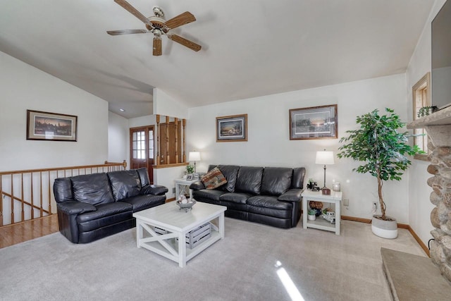 living area with baseboards, carpet flooring, a ceiling fan, and lofted ceiling