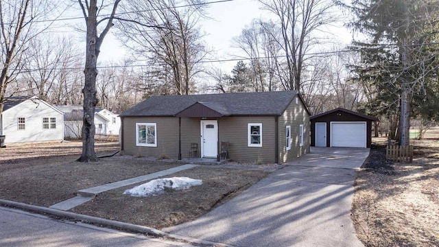 view of front of house featuring an outbuilding, driveway, a detached garage, and a shingled roof