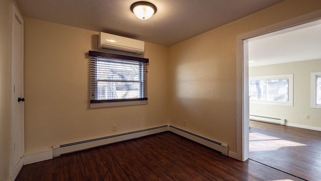 empty room featuring a baseboard heating unit, baseboards, a wall unit AC, baseboard heating, and wood finished floors