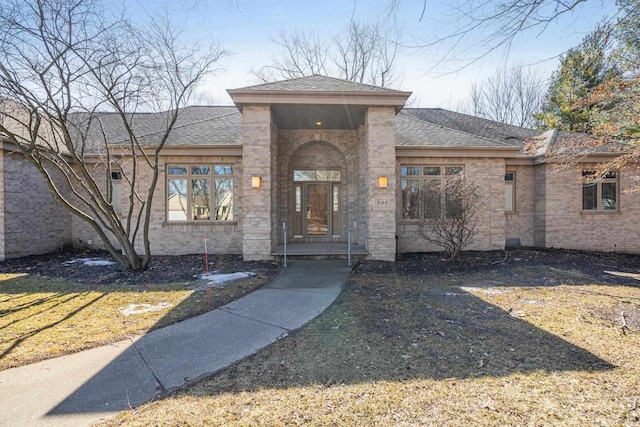 view of front of house featuring brick siding and a shingled roof