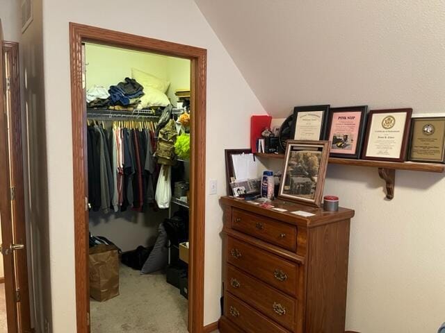 bedroom featuring a closet, carpet floors, visible vents, and vaulted ceiling