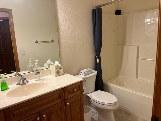 full bathroom with tile patterned floors, toilet, shower / tub combination, vanity, and a textured wall