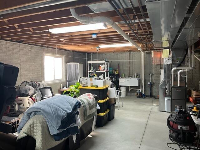 basement with heating unit and a sink