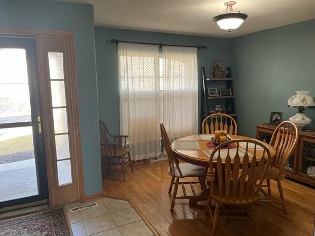 dining area with visible vents and light wood-type flooring