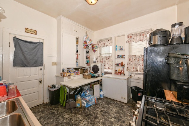 kitchen featuring white fridge, freestanding refrigerator, and white cabinetry