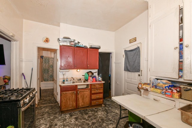 kitchen with a sink, stainless steel range with gas stovetop, and light countertops