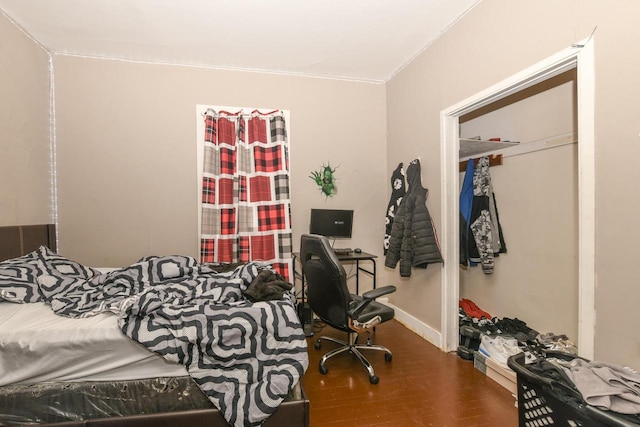 bedroom with crown molding, baseboards, and wood finished floors