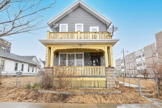 view of front of home with a balcony, fence, and covered porch