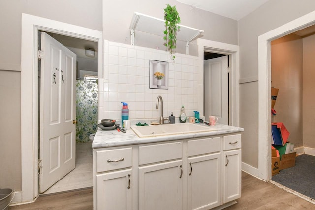 bathroom featuring vanity, baseboards, and wood finished floors