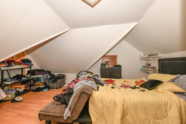 bedroom with vaulted ceiling and wood finished floors