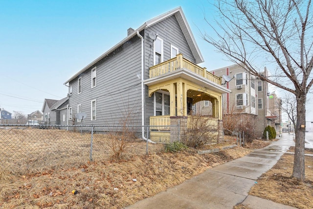 view of side of home featuring a balcony and fence