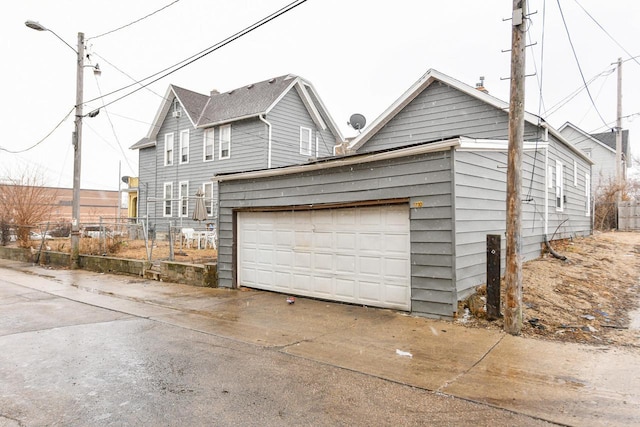 garage with driveway and fence