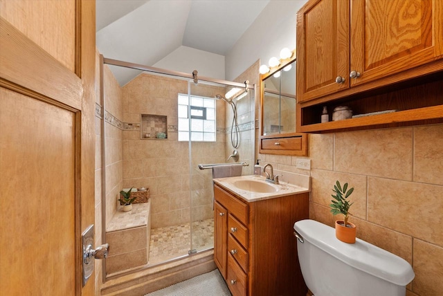 bathroom featuring vanity, lofted ceiling, toilet, and a stall shower